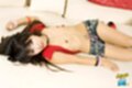 Aon lying on couch shirt open small tits wearing shorts