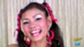Smiling broadly wearing hoop earrings